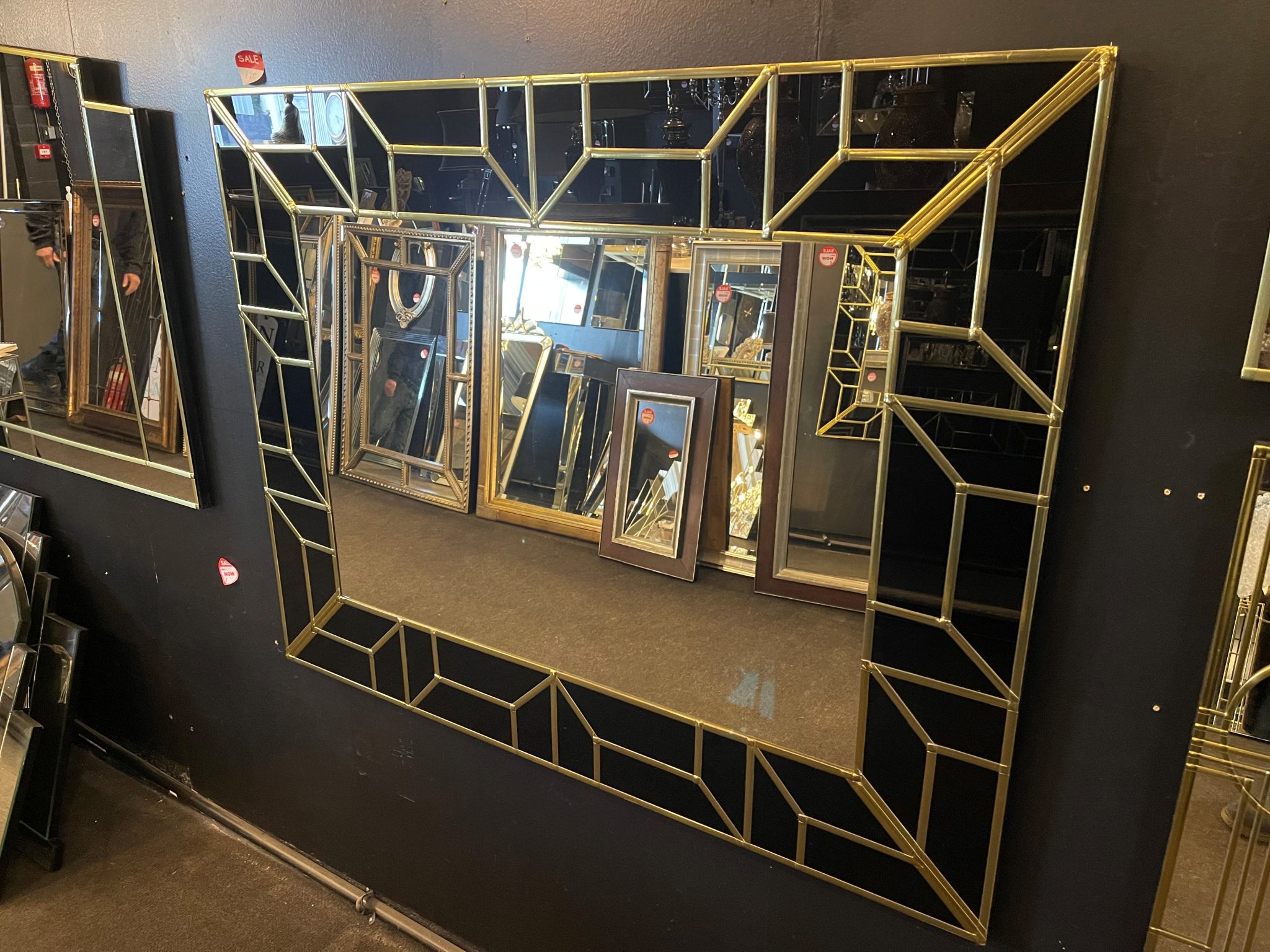 The Atticus Handcrafted Art Deco Glam Wall Mirror has been handmade in our Norfolk workshop by our in house designer – Phillip Orr. This attractive, handmade art deco mirror will add a touch of glamour to any room. Featuring a jet black glass border, with a geometric design in gold, and a central plain mirror.